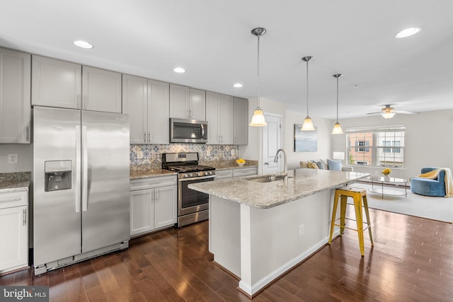 9950 Ravenhurst Rd, Middle River, MD 21220 - kitchen with stainless steel appliances, dark wood-style floors, open floor plan, tasteful backsplash, and light stone countertops
