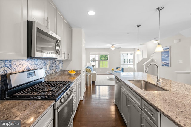 9950 Ravenhurst Rd, Middle River, MD 21220 - kitchen with stainless steel appliances, dark wood-style flooring, light stone countertops, backsplash, and pendant lighting