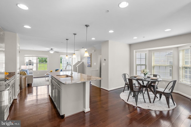 9950 Ravenhurst Rd, Middle River, MD 21220 - kitchen featuring light stone counters, dark wood-type flooring, a center island with sink, recessed lighting, and pendant lighting