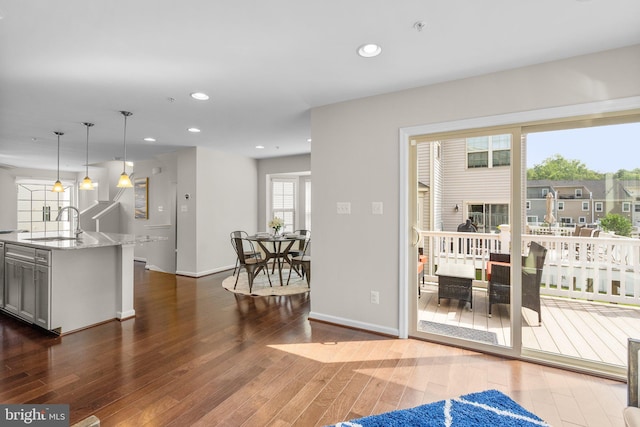 9950 Ravenhurst Rd, Middle River, MD 21220 - kitchen featuring wood finished floors, light stone countertops, recessed lighting, decorative light fixtures, and a kitchen island with sink