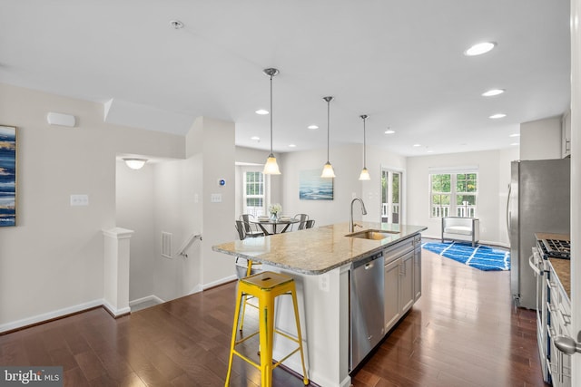 9950 Ravenhurst Rd, Middle River, MD 21220 - kitchen featuring dark wood-style floors, stainless steel appliances, a kitchen island with sink, light stone countertops, and recessed lighting