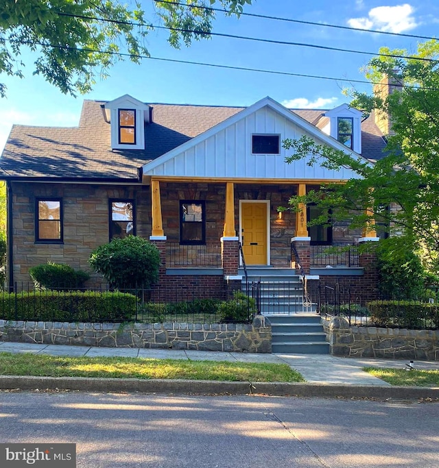 801 Van Buren St NW, Washington, DC 20012 - view of front of property with stone siding, covered porch, a shingled roof, and board and batten siding