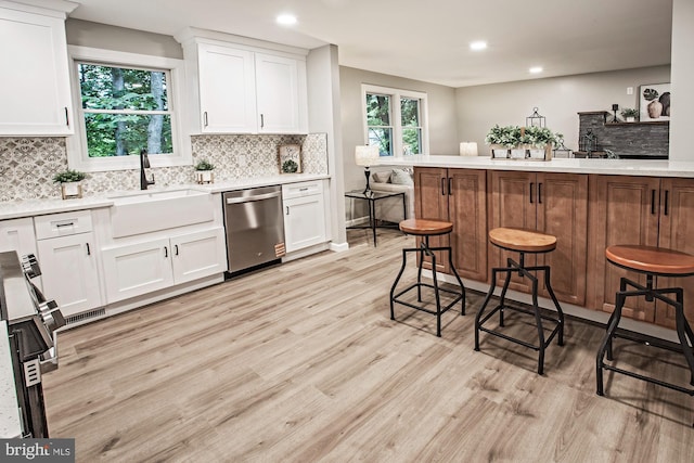 118 Bock Ave, Wenonah, NJ 08090 - kitchen featuring dishwasher, a sink, light wood finished floors, a breakfast bar area, and tasteful backsplash