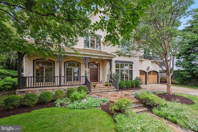 5420 Moorland Ln, Bethesda, MD 20814 - view of front of home featuring stucco siding, covered porch, and driveway