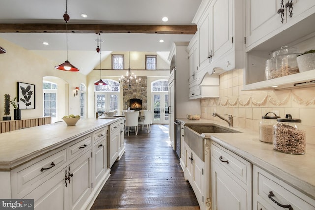 5420 Moorland Ln, Bethesda, MD 20814 - kitchen with a sink, white cabinets, decorative backsplash, light countertops, and dark wood-style flooring