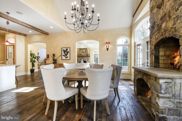 5420 Moorland Ln, Bethesda, MD 20814 - dining room with arched walkways, a stone fireplace, dark wood-style floors, a chandelier, and recessed lighting