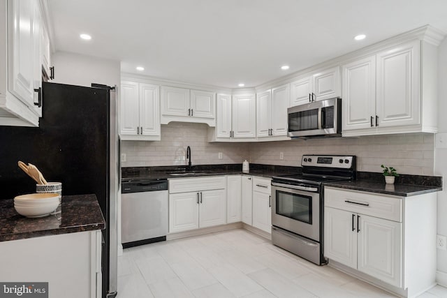 12711 Lampton Ln, Fort Washington, MD 20744 - kitchen with appliances with stainless steel finishes, a sink, white cabinetry, decorative backsplash, and recessed lighting