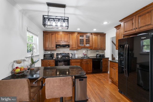 13413 Winterspoon Ln, Germantown, MD 20874 - kitchen with black appliances, brown cabinets, crown molding, light wood finished floors, and backsplash