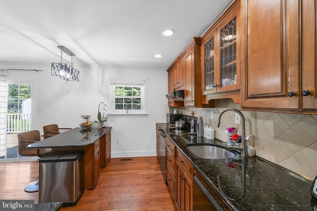 13413 Winterspoon Ln, Germantown, MD 20874 - kitchen featuring brown cabinets, plenty of natural light, dark stone countertops, tasteful backsplash, and crown molding