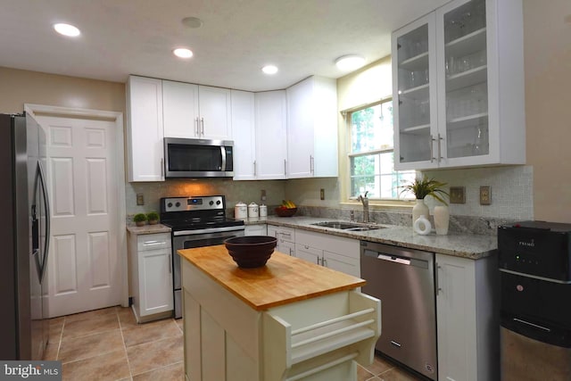8307 Satinleaf Ct, Bowie, MD 20715 - kitchen with stainless steel appliances, wood counters, decorative backsplash, white cabinets, and glass insert cabinets