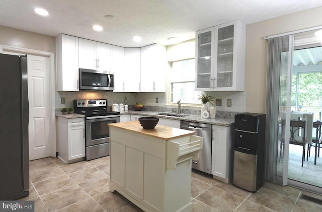 8307 Satinleaf Ct, Bowie, MD 20715 - kitchen featuring stainless steel appliances, wooden counters, decorative backsplash, glass insert cabinets, and recessed lighting