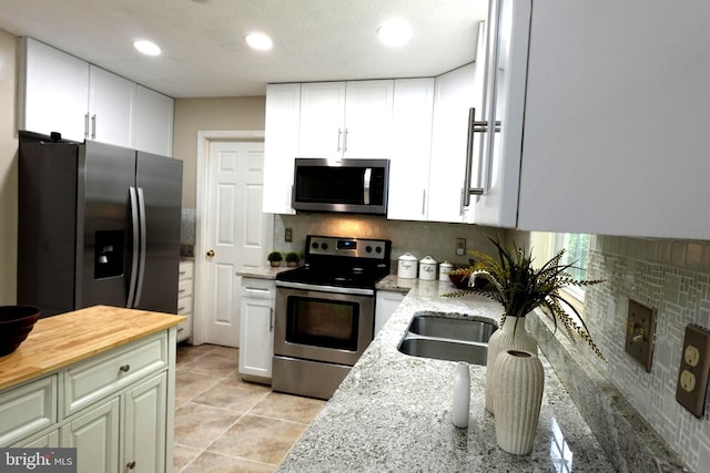 8307 Satinleaf Ct, Bowie, MD 20715 - kitchen featuring appliances with stainless steel finishes, backsplash, light stone countertops, white cabinets, and recessed lighting