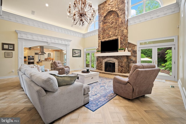14 Waterfront Way, Hammonton, NJ 08037 - living room with a towering ceiling, baseboards, arched walkways, a stone fireplace, and a chandelier