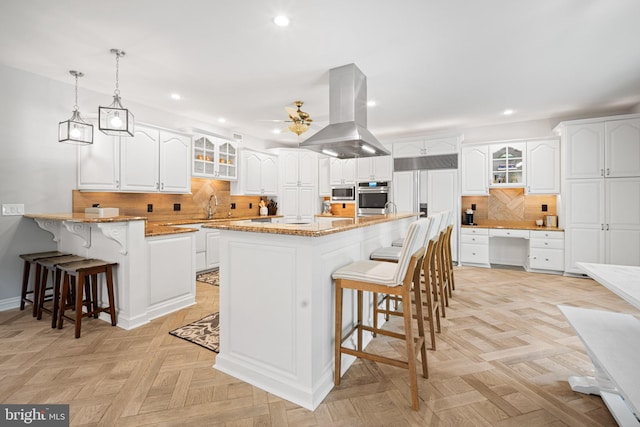 14 Waterfront Way, Hammonton, NJ 08037 - kitchen featuring island range hood, stainless steel appliances, a breakfast bar area, recessed lighting, and glass insert cabinets