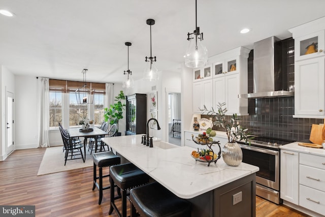 123 Quartz Ridge Rd Unit 28, Hanover, PA 17331 - kitchen featuring wall chimney range hood, stainless steel range with electric stovetop, a sink, backsplash, and a center island with sink