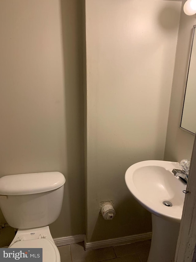 3918 Dudley Ave, Baltimore, MD 21213 - half bathroom featuring tile patterned floors, toilet, baseboards, and a sink