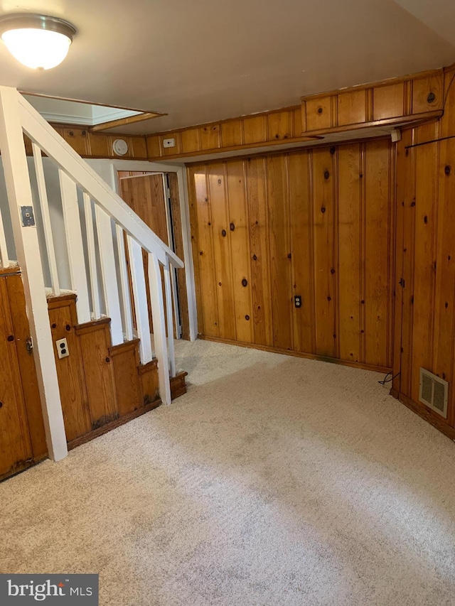 3918 Dudley Ave, Baltimore, MD 21213 - below grade area featuring carpet flooring, stairs, and wooden walls