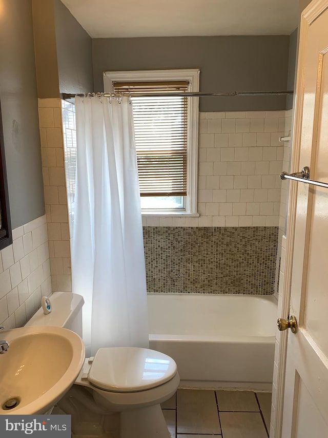 3918 Dudley Ave, Baltimore, MD 21213 - bathroom featuring tile patterned flooring, toilet, a sink, shower / bath combo, and tile walls