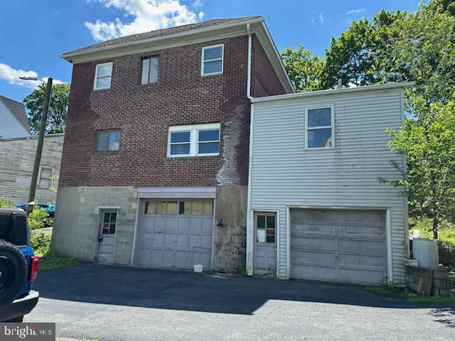 901 W Wade Rd, Saint Clair, PA 17970 - back of house with brick siding, a garage, and driveway
