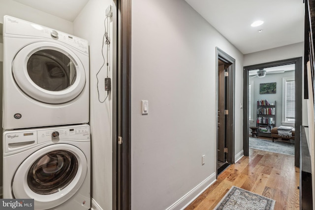 1444 N Myrtlewood St, Philadelphia, PA 19121 - laundry room featuring stacked washing machine and dryer, light wood-style floors, and baseboards