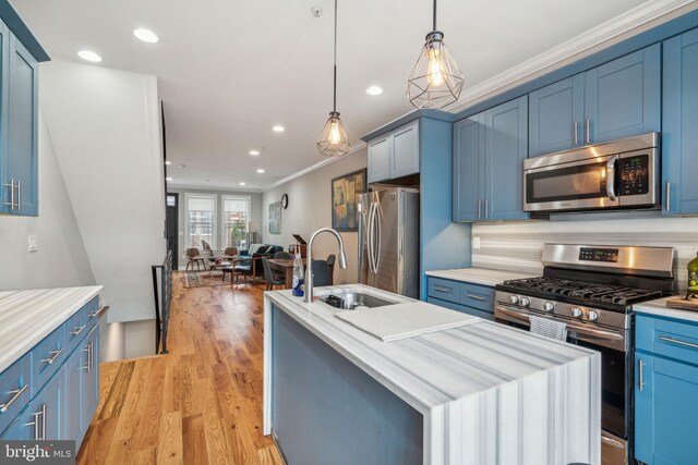 1444 N Myrtlewood St, Philadelphia, PA 19121 - kitchen featuring stainless steel appliances, blue cabinetry, crown molding, a kitchen island with sink, and a sink