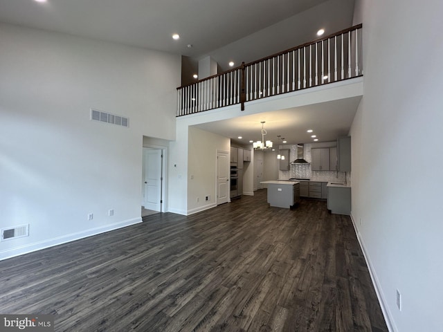 21 Kay Chiarello Way, Hamilton, NJ 08690 - unfurnished living room with recessed lighting, dark wood-type flooring, a towering ceiling, baseboards, and a chandelier