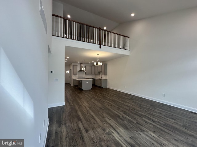 21 Kay Chiarello Way, Hamilton, NJ 08690 - unfurnished living room featuring dark wood-type flooring, high vaulted ceiling, recessed lighting, a sink, and baseboards