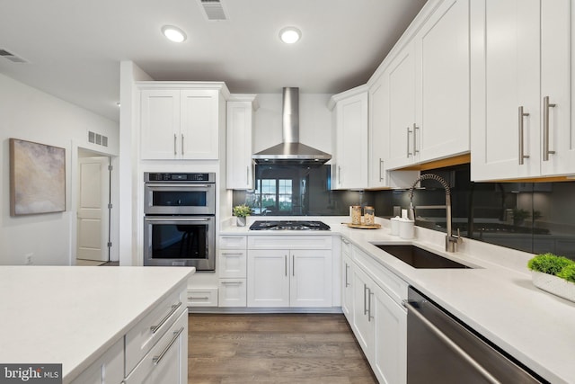 210 Decoverly Dr Unit 407, Gaithersburg, MD 20878 - kitchen featuring wall chimney exhaust hood, stainless steel appliances, a sink, white cabinets, and recessed lighting