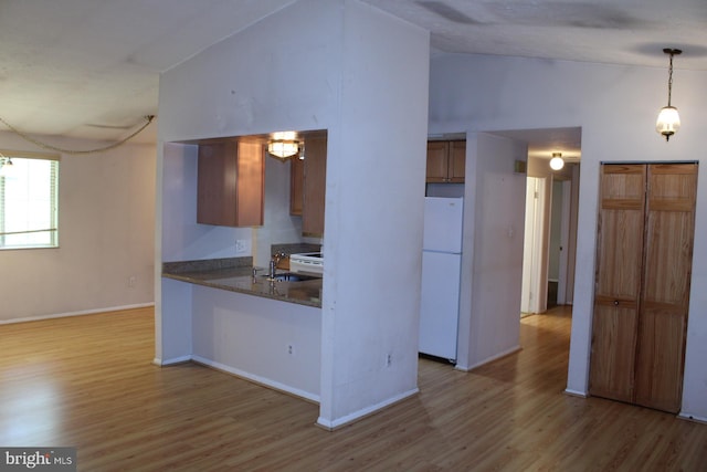 8406 Rainbow Bridge Ln, Springfield, VA 22153 - kitchen with freestanding refrigerator, lofted ceiling, light wood-style floors, a peninsula, and dark countertops