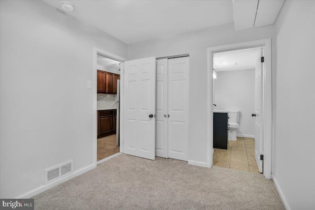 2429 Patton St, Camden, NJ 08104 - unfurnished bedroom featuring light colored carpet, baseboards, a closet, freestanding refrigerator, and ensuite bathroom