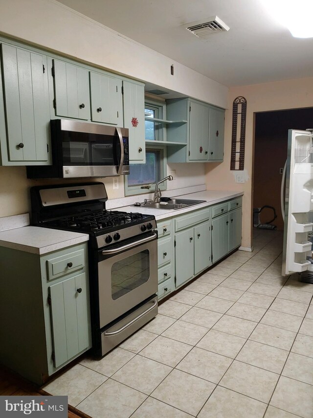 612 Deerhead Lake Dr, Forked River, NJ 08731 - kitchen featuring appliances with stainless steel finishes, a sink, open shelves, light countertops, and light tile patterned flooring