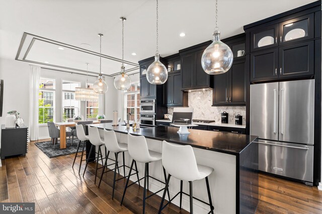 1741 Mckenna Point Dr Unit 2701, Mclean, VA 22102 - kitchen with stainless steel appliances, tasteful backsplash, recessed lighting, a kitchen breakfast bar, and a kitchen island with sink