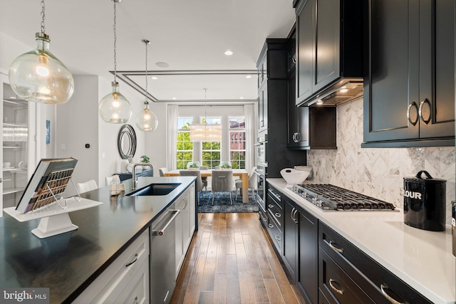 1741 Mckenna Point Dr Unit 2701, Mclean, VA 22102 - kitchen featuring a sink, stainless steel appliances, tasteful backsplash, dark wood finished floors, and decorative light fixtures