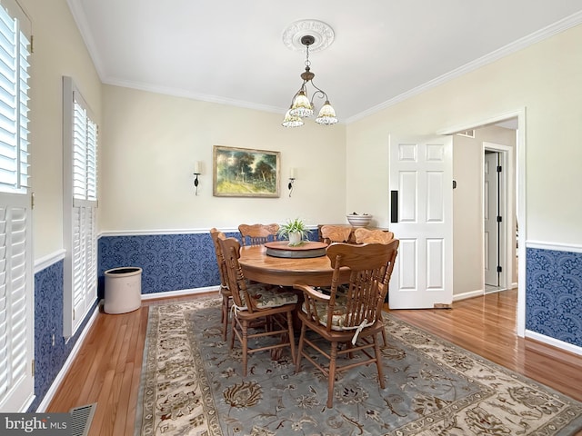 5590 Broadmoor Ter N, Ijamsville, MD 21754 - dining room with wood finished floors, ornamental molding, baseboards, a wainscoted wall, and a chandelier