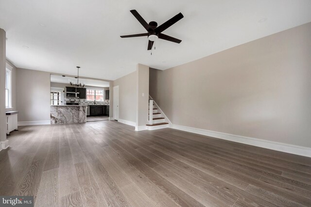170 Drexel Ave, Lansdowne, PA 19050 - unfurnished living room with a chandelier, dark wood-type flooring, a ceiling fan, stairs, and baseboards