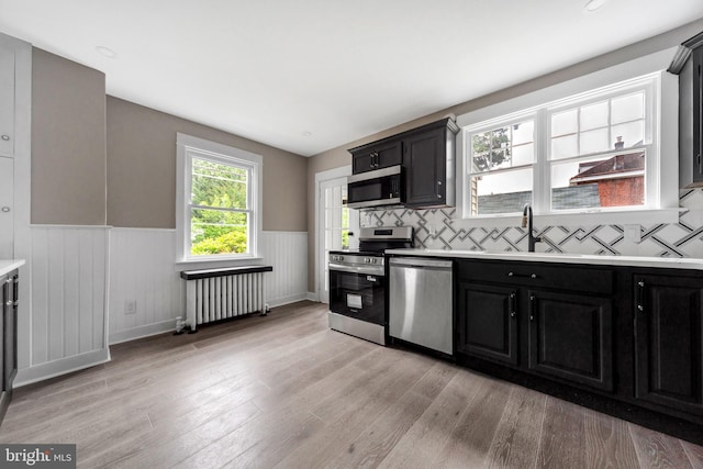 170 Drexel Ave, Lansdowne, PA 19050 - kitchen featuring stainless steel appliances, radiator, wainscoting, dark cabinets, and a sink