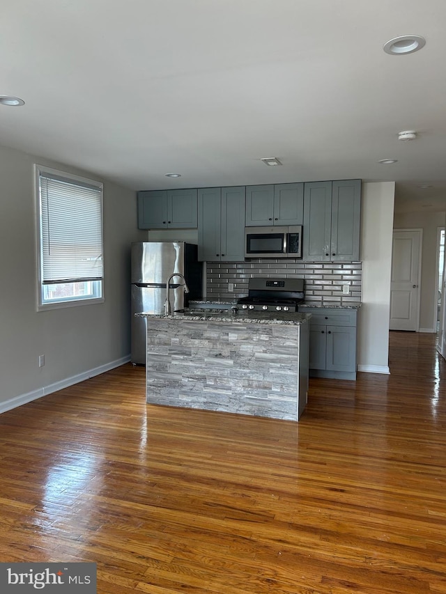 5221 N 8th St, Philadelphia, PA 19120 - kitchen with appliances with stainless steel finishes, baseboards, gray cabinets, decorative backsplash, and dark wood-type flooring