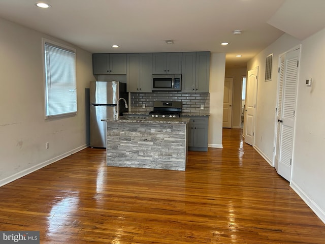 5221 N 8th St, Philadelphia, PA 19120 - kitchen featuring appliances with stainless steel finishes, gray cabinetry, dark wood-style flooring, recessed lighting, and a kitchen island with sink