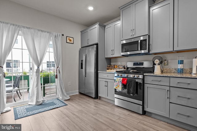108 Annapolis St, Bensalem, PA 19020 - kitchen with appliances with stainless steel finishes, gray cabinets, light wood finished floors, light stone countertops, and baseboards
