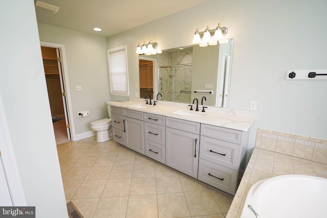 5991 Bell Creek Dr, Salisbury, MD 21801 - bathroom featuring a shower stall, double vanity, tile patterned flooring, a walk in closet, and toilet