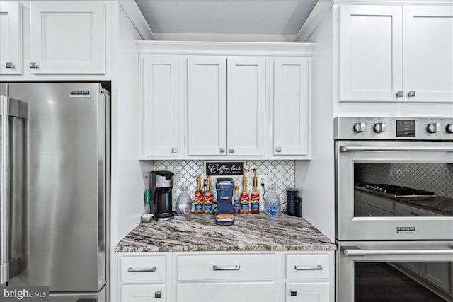 308 Walnut Dr, Fredericksburg, VA 22405 - kitchen with stainless steel refrigerator, multiple ovens, white cabinetry, tasteful backsplash, and stone countertops
