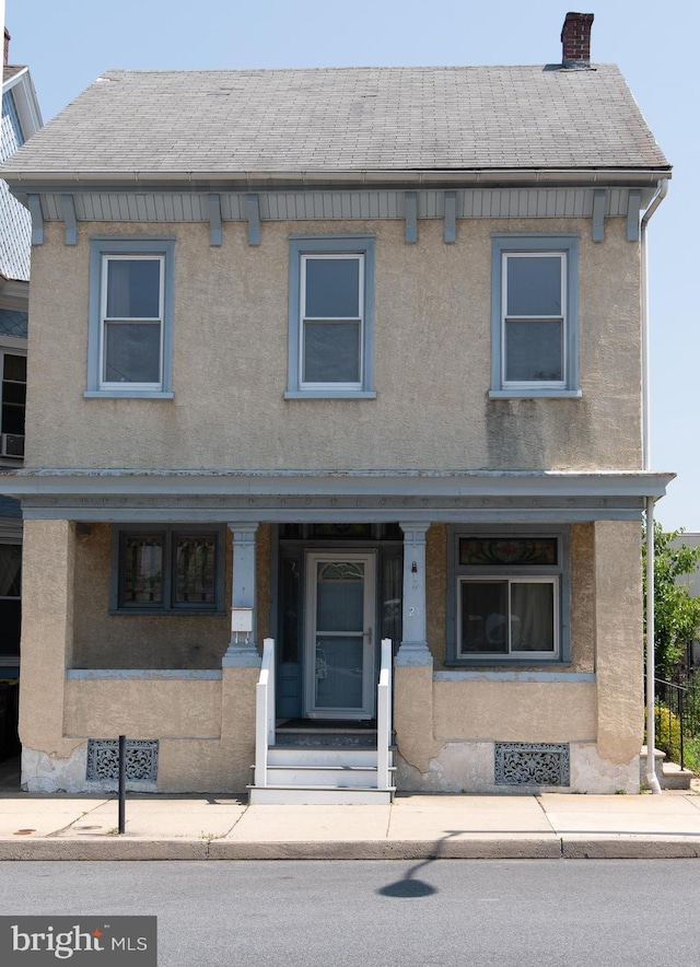 21 E 3rd St, Boyertown, PA 19512 - townhome / multi-family property with covered porch, a chimney, stucco siding, and a shingled roof