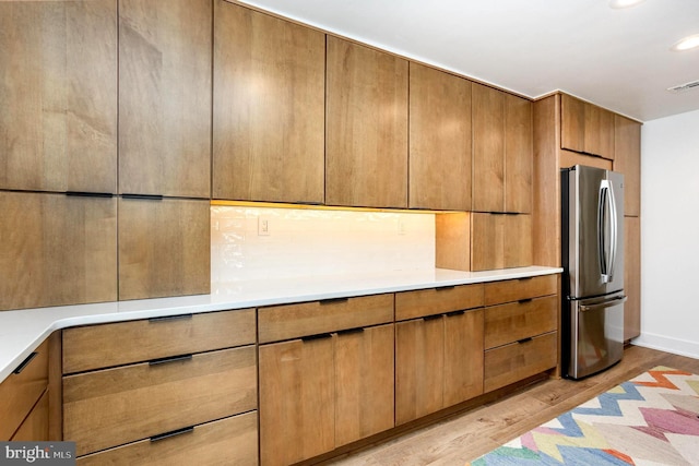 3801 Canterbury Rd Unit 705, Baltimore, MD 21218 - kitchen with freestanding refrigerator, light wood-type flooring, light countertops, brown cabinets, and recessed lighting