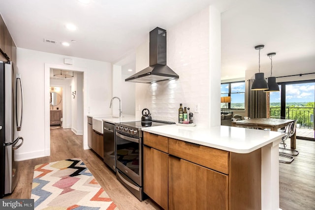 3801 Canterbury Rd Unit 705, Baltimore, MD 21218 - kitchen with extractor fan, stainless steel appliances, light wood-style floors, a sink, and light countertops