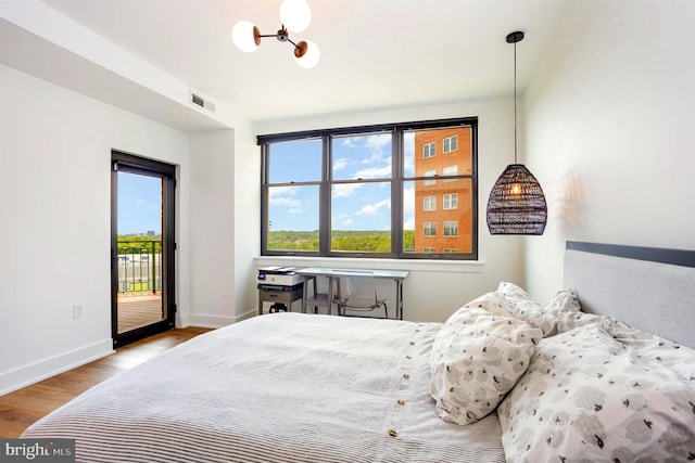 3801 Canterbury Rd Unit 705, Baltimore, MD 21218 - bedroom featuring access to outside, wood finished floors, baseboards, and a chandelier
