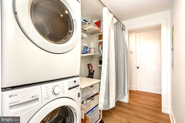 3801 Canterbury Rd Unit 705, Baltimore, MD 21218 - laundry area featuring stacked washing machine and dryer, light wood-style flooring, and baseboards
