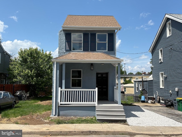 4210 W 7th St, Marcus Hook, PA 19061 - view of front facade with covered porch, a shingled roof, and stucco siding