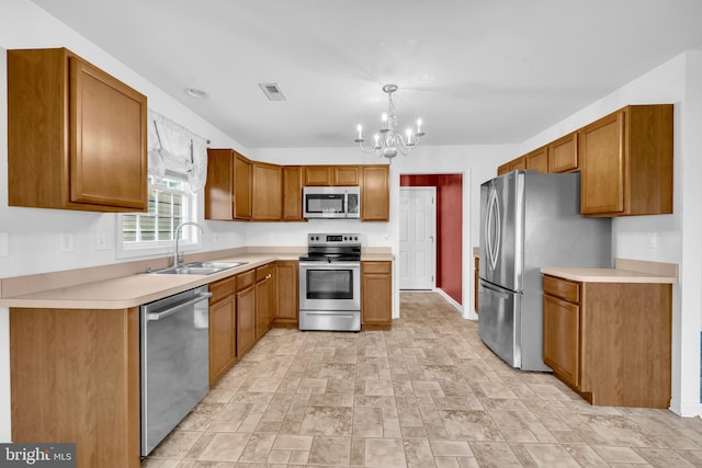 15 Ridgeway Dr, Ridgely, MD 21660 - kitchen featuring appliances with stainless steel finishes, a chandelier, brown cabinets, light countertops, and stone finish flooring