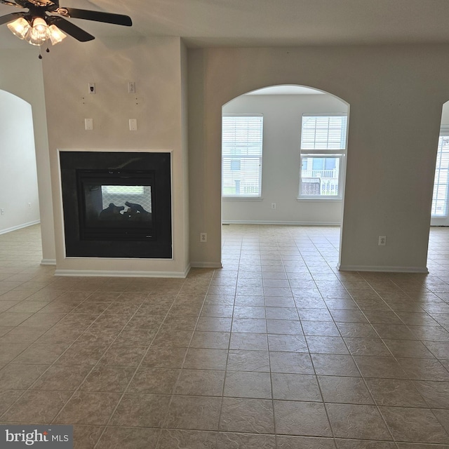16288 Corkscrew Ct Unit 203, Lewes, DE 19958 - unfurnished living room with plenty of natural light, a multi sided fireplace, ceiling fan, and arched walkways