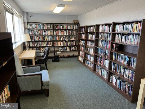 4515 Willard Ave Unit 2309S, Chevy Chase, MD 20815 - sitting room featuring bookshelves and carpet flooring